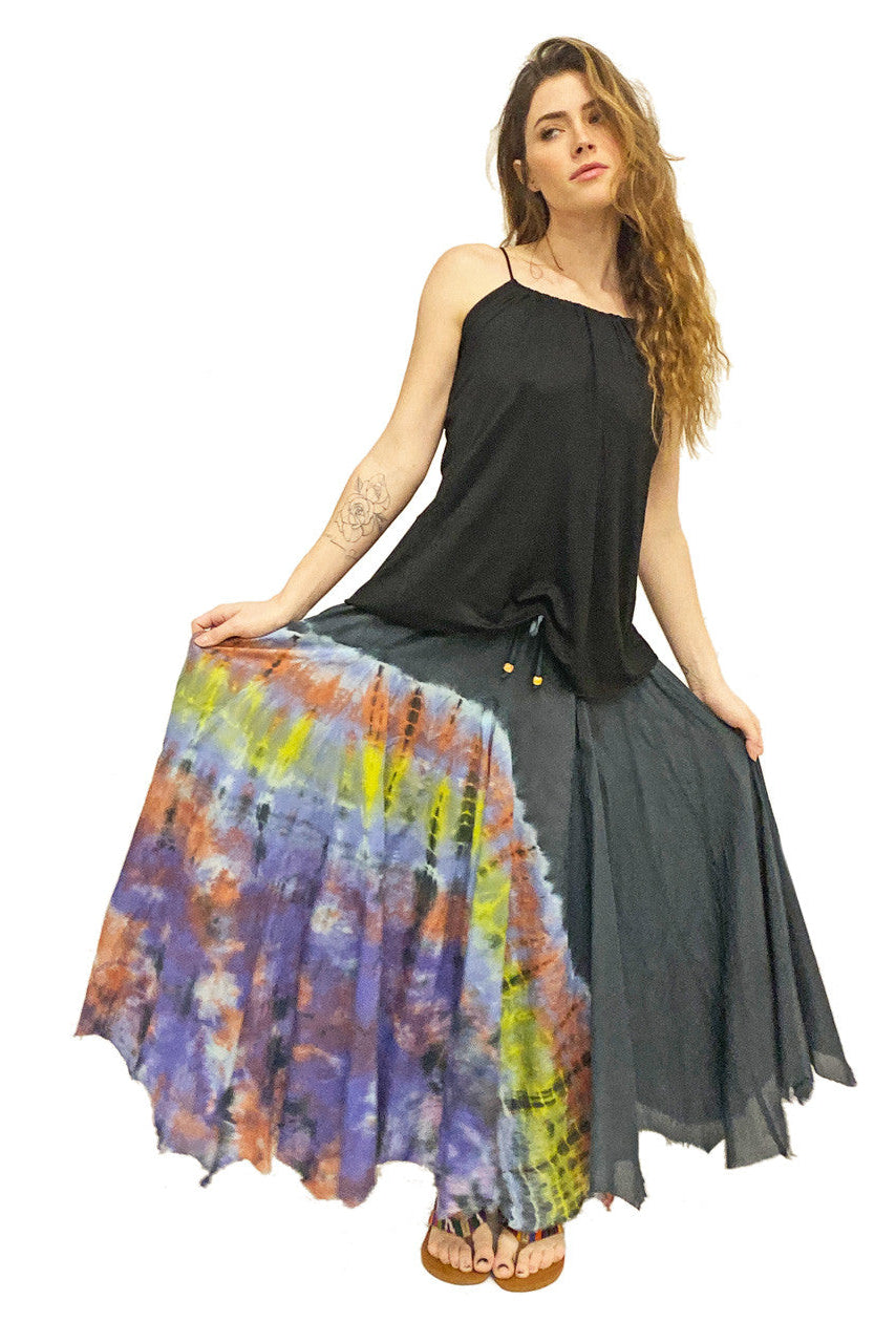 Woman wearing a black top and colorful tie-dye skirt on a white background